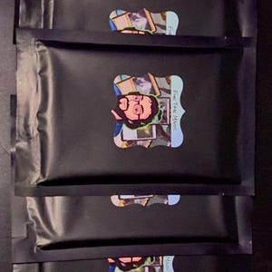 May include: Five black resealable pouches with colorful labels. Each label features a cartoon illustration of a person with glasses and the text "Four Time Magic".