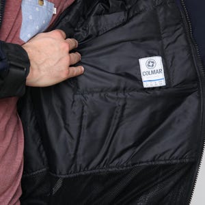 May include: A navy blue jacket with a black mesh lining and a white label that says "COLMAR" with size information.