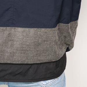 May include: A navy blue jacket with a gray and black trim. The jacket has a quilted lining.