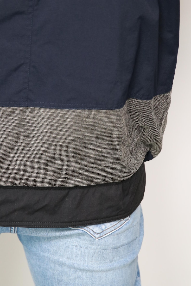 May include: A navy blue jacket with a gray and black trim. The jacket has a quilted lining.