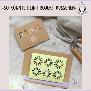 May include: Two brown cardstock cards with cut-out designs. The first card has the word "DANKE" cut out and a small flower design. The second card has six flower designs cut out. The cards are on a light brown fabric background.