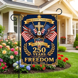 Könnte beinhalten: Eine dunkelblaue Gartenflagge mit patriotischen Motiven: ein Adler, amerikanische Flaggen und der Text "ONE NATION UNDER GOD" und "250 YEARS OF FREEDOM 1776-2026". Die Flagge ist in einem Garten aufgestellt.