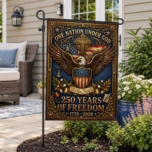 Könnte beinhalten: Eine dekorative Gartenflagge mit patriotischem Design. Die Flagge zeigt einen Adler, die amerikanische Flagge und den Text "One Nation Under God" und "250 Years of Freedom 1776-2026" in goldener Schrift auf blauem Hintergrund.