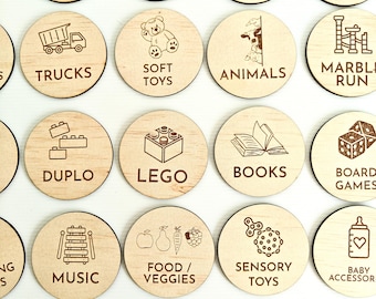 May include: Wooden circle tokens with various images and text, including "Blocks", "Play-Doh", "Kitchen", "Jenga", "Trucks", "Soft Toys", "Animals", "Marble Run", "Duplo", "Lego", "Books", "Board Games", "Music", "Food/Veggies", "Sensory Toys", "Baby Accessory", "Puzzles", "Tools", "Action Figures", and "Bare".