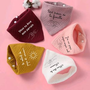 K&ouml;nnte beinhalten: F&uuml;nf Baby-L&auml;tzchen in verschiedenen Farben, darunter Burgunderrot, Rosa, Gelb und Wei&szlig;. Jedes L&auml;tzchen hat einen Druckknopfverschluss und ein einzigartiges Design mit Text und Illustrationen. Die L&auml;tzchen sind aus weichem, strukturiertem Stoff.