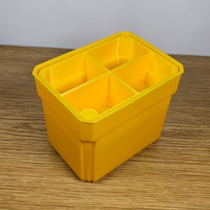 May include: A bright yellow plastic organizer with four compartments. The organizer is empty and ready to be filled with items.