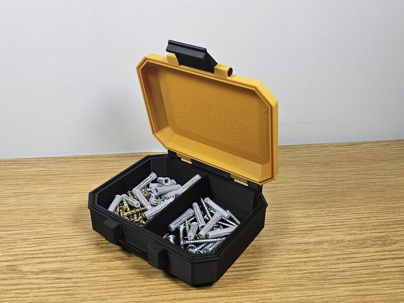 May include: A black and yellow plastic storage box with two compartments filled with screws and nails.