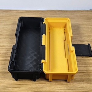 May include: A black and yellow plastic storage case with a hinged lid. The case is open and the inside is empty.