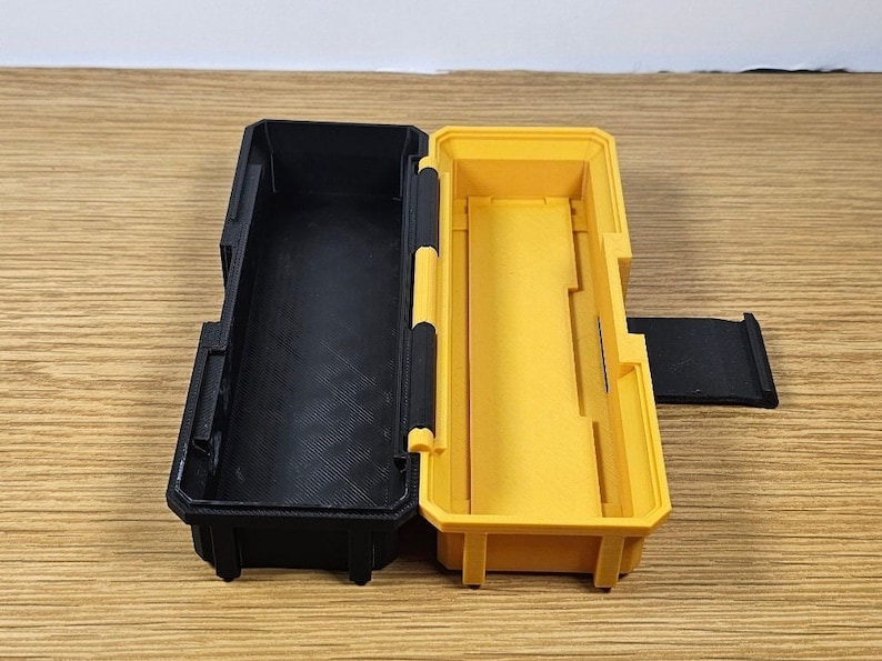 May include: A black and yellow plastic storage case with a hinged lid. The case is open and the inside is empty.