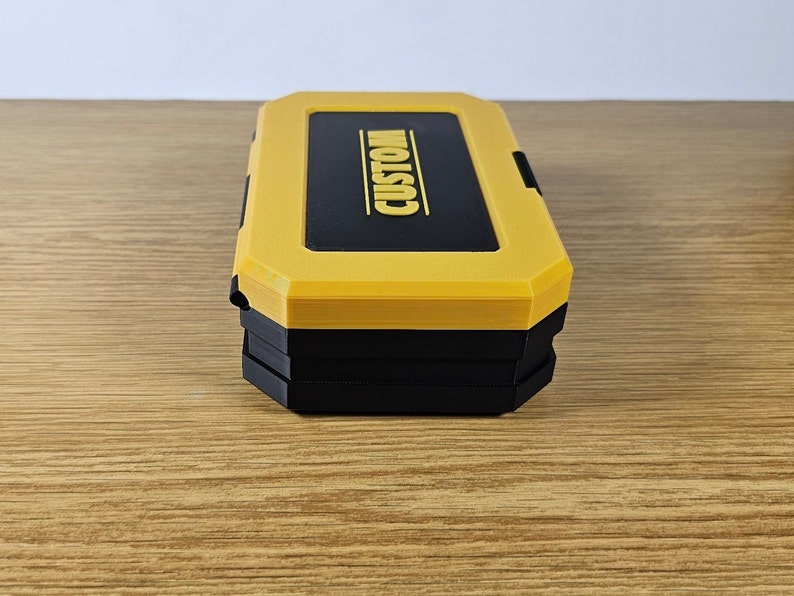 May include: A yellow and black plastic storage box with the word "CUSTOM" printed on the top.