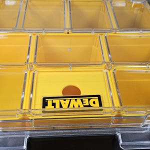 Pode incluir: Organizador de armazenamento de pl&aacute;stico amarelo com compartimentos transparentes e um logotipo DEWALT na frente.