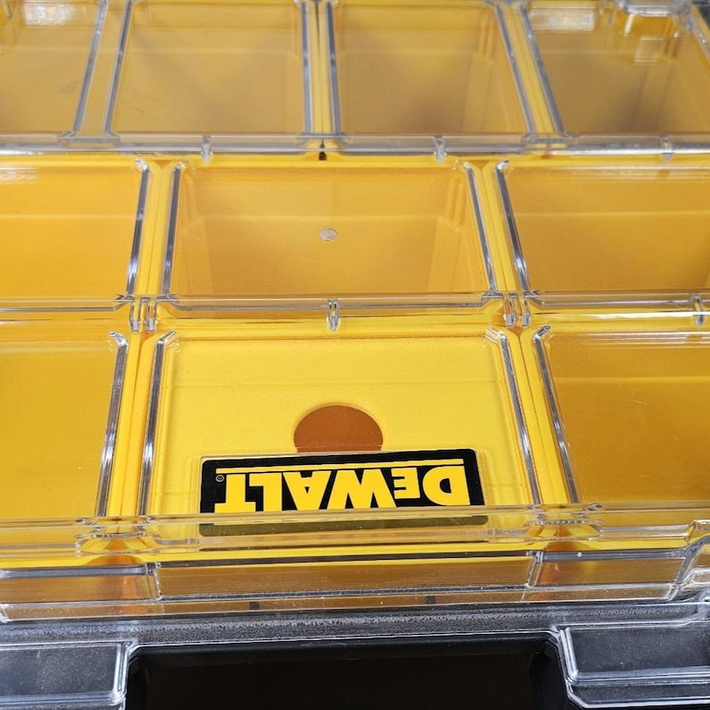 Pode incluir: Organizador de armazenamento de pl&aacute;stico amarelo com compartimentos transparentes e um logotipo DEWALT na frente.