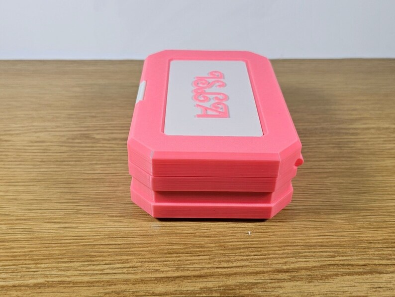 May include: A pink and white plastic case with the text "Get Started" printed on the top. The case is closed and has a textured surface.