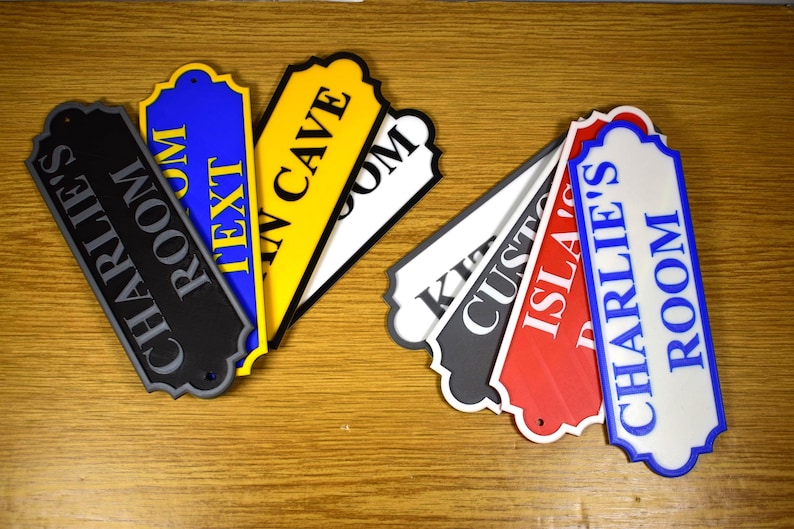 Puede incluir: Una colecci&oacute;n de letreros de habitaci&oacute;n coloridos con varios textos. Los letreros son de color negro, azul, amarillo, rojo y blanco, con texto en colores contrastantes. Los letreros est&aacute;n hechos de un material duradero y est&aacute;n dise&ntilde;ados para uso en interiores.