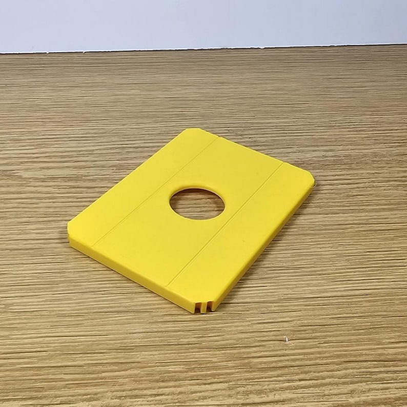 Pode incluir: Uma bandeja de gelo de pl&aacute;stico amarelo com um furo circular no centro. A bandeja tem uma superf&iacute;cie texturizada.