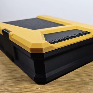 May include: A yellow and black plastic storage box with the text "SMARTSTORE" printed on the top.