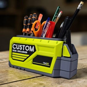 May include: A custom desk organizer in a lime green and gray color scheme, holding various office supplies. The organizer has the text "CUSTOM DESK ORGANISER" and the number "1S425" printed on it. The organizer holds screwdrivers, scissors, pens, and pencils.