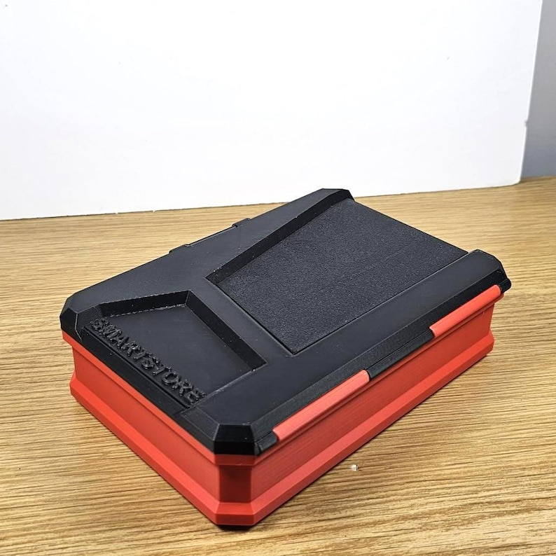 May include: A red and black storage case with the text "SMARTSTORE" printed on the side.