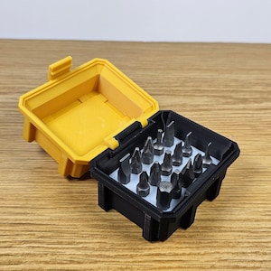 May include: A yellow and black plastic case containing a selection of small screwdriver bits. The case is open, revealing the bits.