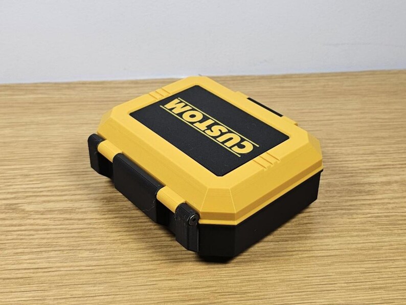 May include: A yellow and black plastic storage case with the word "CUSTOM" printed on the top.