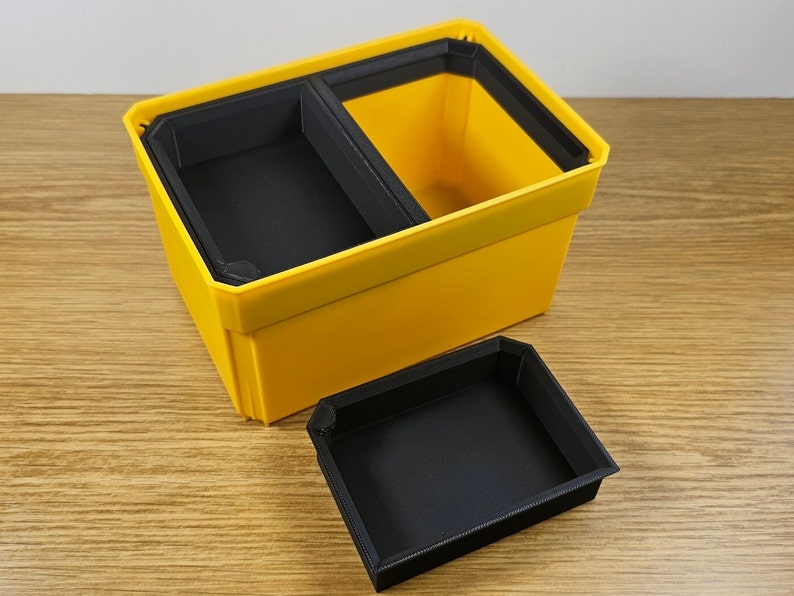 May include: A yellow plastic storage box with a black removable divider. The box is open and the divider is sitting next to it.