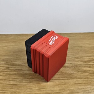 以下が含まれることがあります： 側面に「Chargelife」と印刷された赤と黒のバッテリー充電器