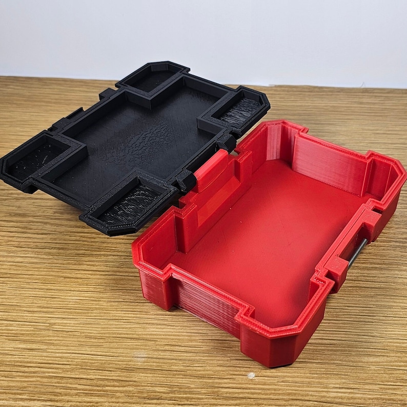 May include: A red plastic storage box with a black lid. The lid has a latch and several compartments. The box is open and empty.
