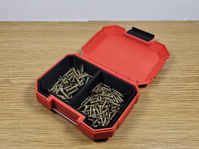 May include: A red plastic storage box with two compartments filled with gold screws.
