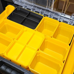 May include: An open black toolbox with multiple yellow plastic compartments. The compartments are various sizes and shapes, and some are divided into smaller sections.