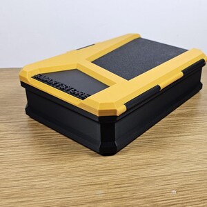 May include: A black and yellow storage box with a textured lid. The box has the words "SMART STORAGE" printed on the front.