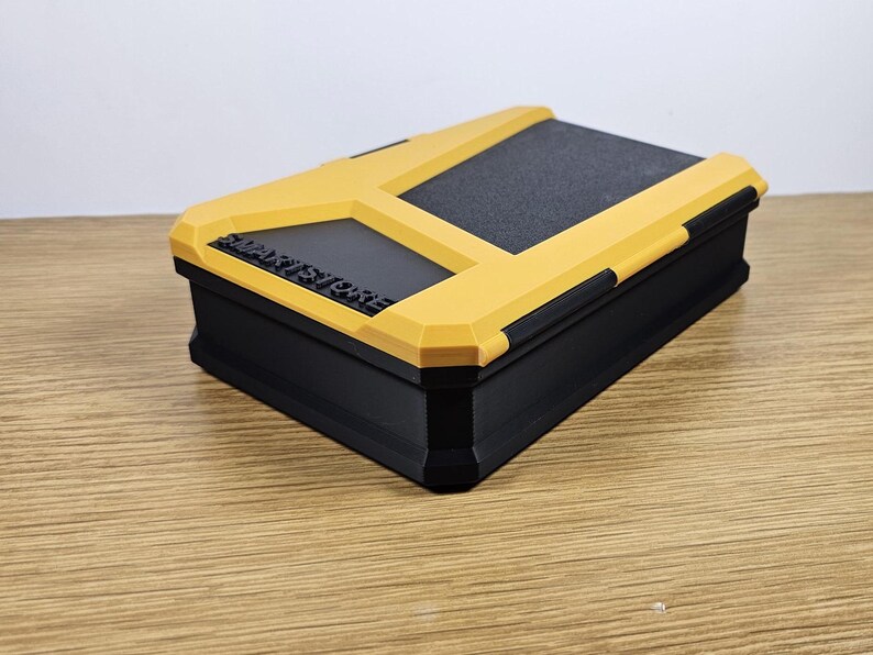 May include: A black and yellow storage box with a textured lid. The box has the words "SMART STORAGE" printed on the front.