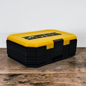 May include: A black and yellow storage box with the word "CUSTOM" on the lid. The box is rectangular with a yellow lid and black body. The box is sitting on a wooden surface.