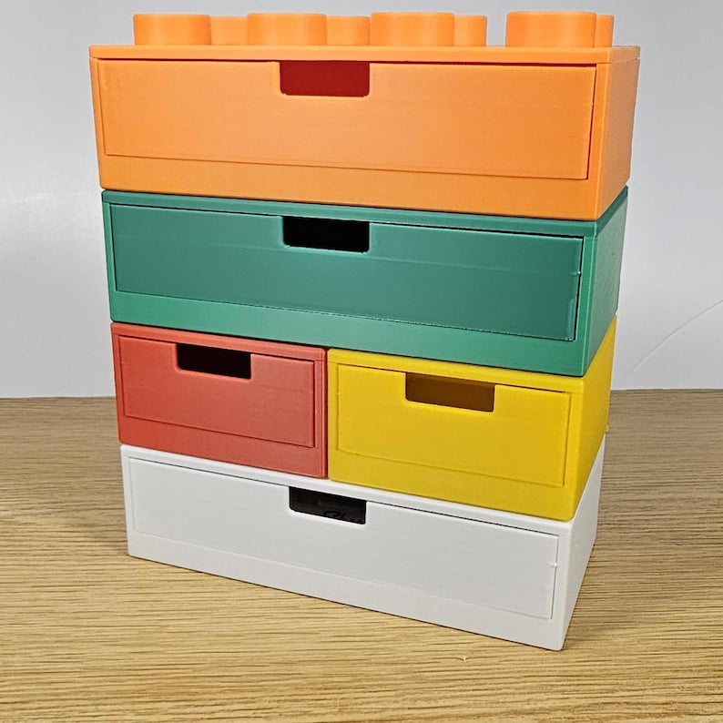 May include: A multi-colored drawer unit with five drawers. The top drawer is orange, the second drawer is green, the third and fourth drawers are red and yellow, and the bottom drawer is white.