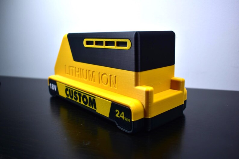 Puede incluir: Un paquete de bater&iacute;as de iones de litio amarillo y negro personalizado. El paquete de bater&iacute;as tiene el texto "LITHIUM ION", "CUSTOM", "18V" y "24AH" impreso. El paquete de bater&iacute;as est&aacute; dise&ntilde;ado para herramientas el&eacute;ctricas.