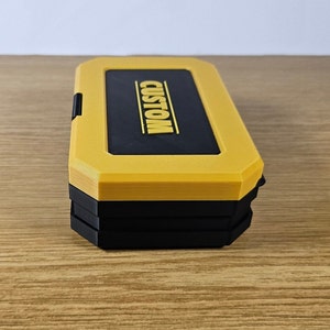 May include: A yellow and black stackable storage box with the word "CUSTOM" printed on the top.