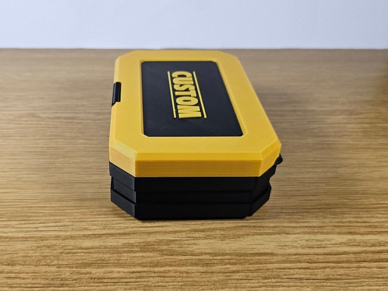 May include: A yellow and black stackable storage box with the word "CUSTOM" printed on the top.