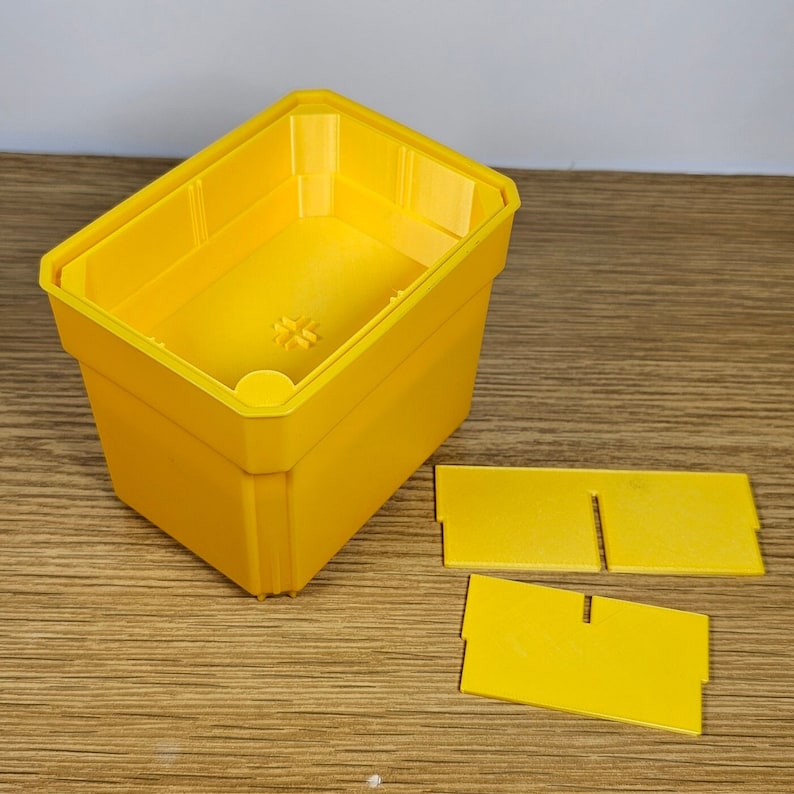May include: A yellow plastic storage box with a lid and three separate compartments. The box is open and the lid is off.