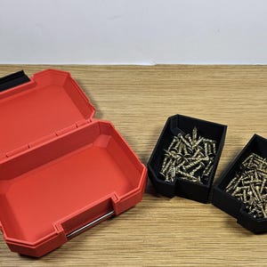 May include: A red plastic storage box with two black plastic containers filled with gold screws. The storage box is open and the containers are closed.