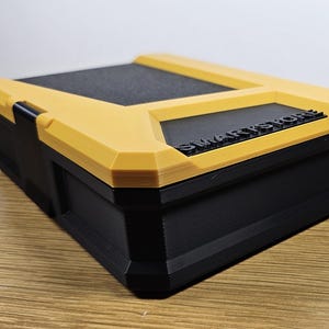 May include: A yellow and black plastic storage box with the word "SMARTSTORE" printed on the top.