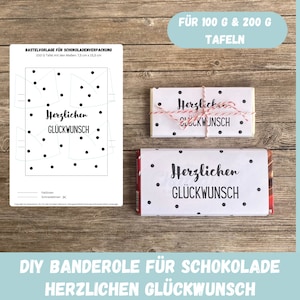 May include: Printable template for a chocolate bar wrapper. The template features a white background with black polka dots and the text "Herzlichen Glückwunsch" which means "Congratulations" in German. The template is designed for 100g and 200g chocolate bars.