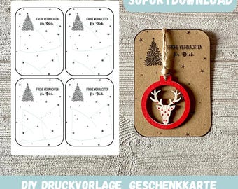 May include: A Christmas-themed image featuring printable gift tags and a wooden ornament. The gift tags have a Christmas tree design and the text "FROHE WEIHNACHTEN für Dich". The ornament is red with a deer design. Text on the image says "SOFORTDOWNLOAD" and "DIY DRUCKVORLAGE GESCHENKKARTE FROHE WEIHNACHTEN".