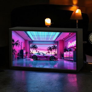 May include: A pink sports car in a garage with neon lights and palm trees. The garage has a sign that says "Garage".