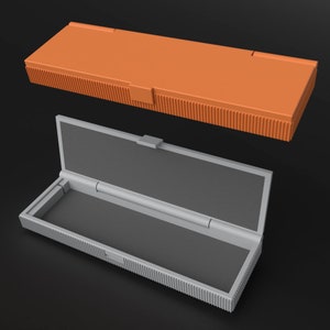 Closed orange and open grey Teenage Engineering OP-Z cases. The grey case displays protective foam inlay, demonstrating custom fit and security for the synthesizer, highlighting color options.