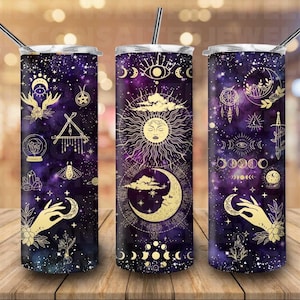 May include: Three stainless steel tumblers with lids and straws. Each tumbler features a different design with gold accents on a purple galaxy background. The designs include a sun, moon, stars, and other celestial symbols.