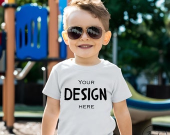 Weiß Bella Canvas 3001 T-Shirt Mockup, Junge weiße Farbe T-Shirt Outdoor Mockup. Boy Sommer Casual Outfit, Spielplatz im Hintergrund, Jpg