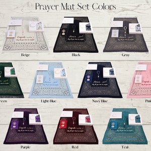 May include: A set of prayer mats in various colors, including beige, black, gray, green, light blue, navy blue, pink, purple, red, and teal. Each mat features a decorative design and includes a matching prayer bead set and a small prayer book.