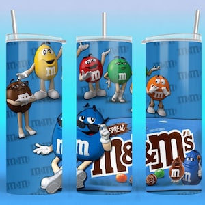 Könnte beinhalten: Drei Edelstahlbecher mit Deckeln und Strohhalmen. Jeder Becher hat einen blauen Hintergrund mit M&M's-Charakteren und dem M&M's-Logo. Das Design enthält die Wörter "SPREAD" und "CHOCOLATE CANDIES".
