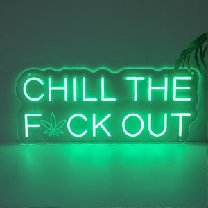 Może przedstawiać: Zielony neonowy znak z tekstem "Chill the F*ck Out" z symbolem liścia marihuany w miejscu "K".
