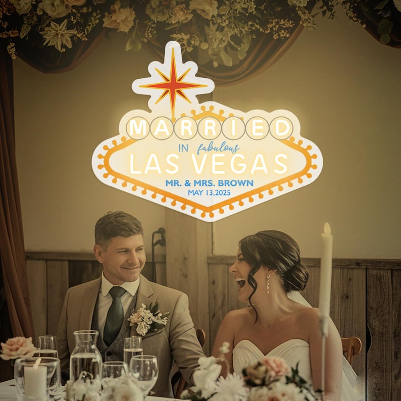 K&ouml;nnte beinhalten: Hochzeitsfeier mit einem Neonschild &uuml;ber dem Paar. Auf dem Schild steht "MARRIED IN fabulous LAS VEGAS" mit den Namen des Paares und dem Hochzeitsdatum. Das Schild ist wei&szlig; und orange. Das Paar l&auml;chelt.