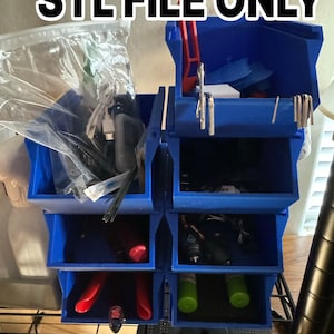 Peut inclure: Un organiseur d'outils bleu imprimé en 3D avec plusieurs compartiments et tiroirs. Le texte "STL FILE ONLY" est affiché en haut. Divers outils et articles sont rangés à l'intérieur, notamment des pinces, des clés et de petites bouteilles.